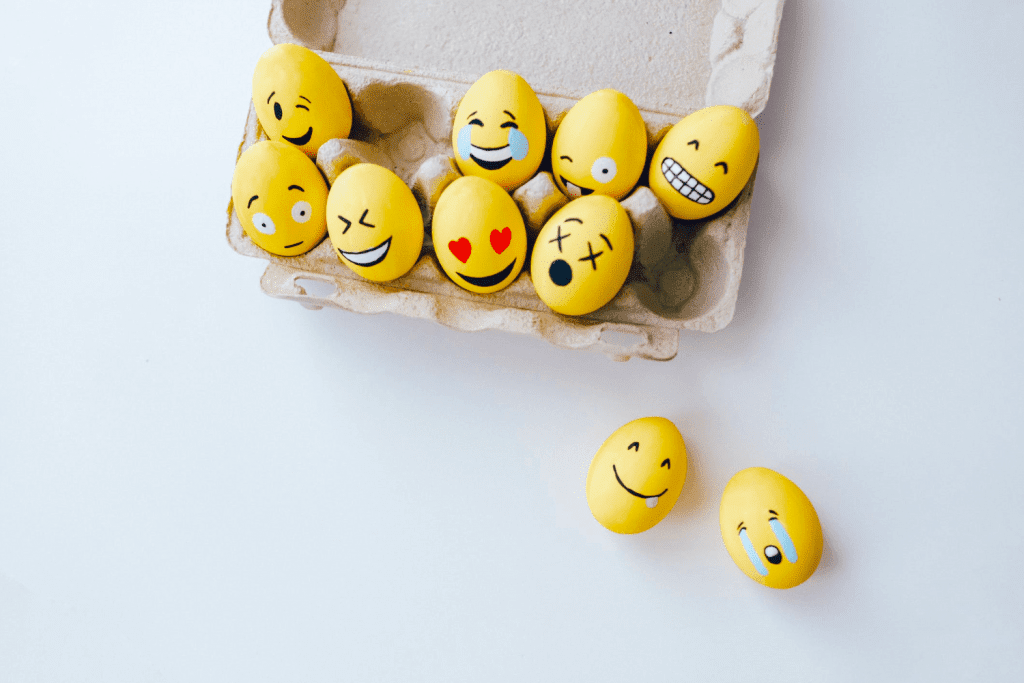 a carton of eggs with faces painted on them.